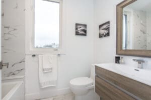 Bright modern bathroom with white walls and wood vanity.