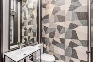 Modern bathroom with geometric patterned wall tiles.