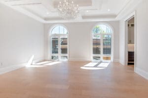 Bright, spacious room with arched windows and chandelier.