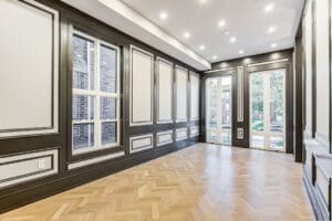 Bright, spacious room with large windows and parquet flooring.