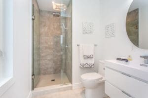 Modern bathroom with glass shower and white fixtures.