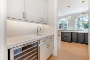 Modern kitchen with white cabinetry and built-in wine cooler.