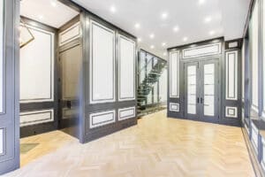 Elegant modern interior with black and white paneling and wooden flooring.