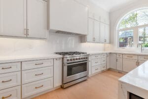 Modern kitchen with white cabinetry and stainless steel stove.