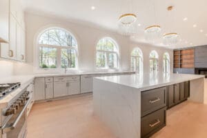 Bright modern kitchen with large arched windows and a spacious island.