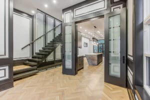 Modern interior with glass doors and floating staircase.