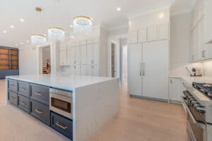 Modern kitchen with white cabinetry and marble island.
