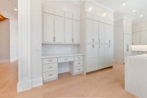 Bright, spacious white built-in cabinets with a desk area in a modern room.