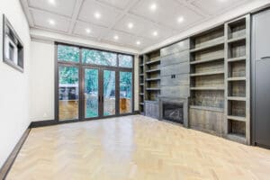 Spacious modern living room with built-in shelves and large glass doors.