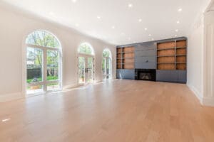 Bright, spacious living room with large arched windows and modern fireplace.