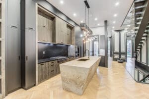 Modern kitchen with marble island and recessed lighting.