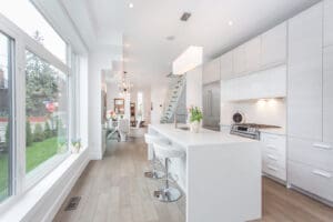 Bright modern kitchen with white cabinetry and island seating.