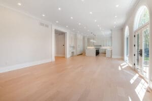 Spacious, bright open-plan living area with light wood floors and white walls.
