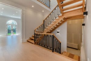 Modern wooden staircase with black metal railings in a bright home.