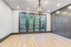 Bright room with wooden floors and large glass doors opening to a balcony.