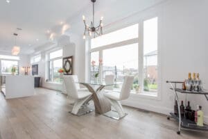 Modern dining area with white chairs and large windows.