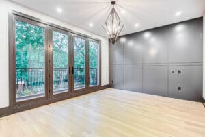 Empty modern room with large windows and wooden floor.