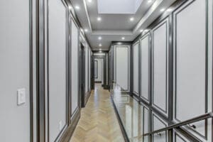 Elegant hallway with paneled walls and recessed lighting.