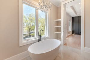 Elegant bathroom with a freestanding tub under a large window.