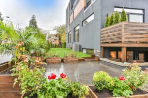 Modern backyard patio with fireplace and garden plants.
