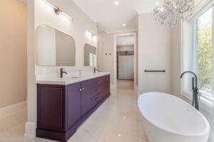 Modern bathroom with purple vanity and freestanding tub.