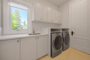 Modern laundry room with washer, dryer, and white cabinetry.