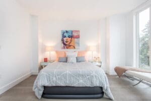 Cozy bedroom with a plush bed, soft lighting, and modern decor.