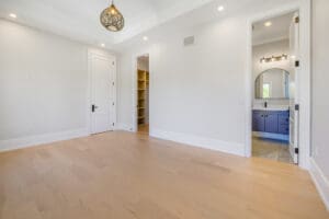 Empty bright room with light wood floors and a chandelier.