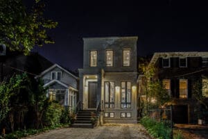A charming two-story house illuminated at night with warm lights.