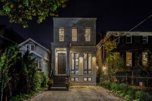 Modern two-story house with warm lighting at night.