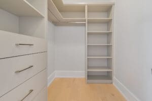 Empty walk-in closet with built-in shelves and drawers.