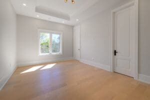Bright empty room with wooden floor and large window.