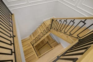 Top-down view of a wooden staircase with black metal railings.