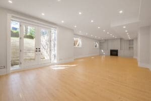 Bright empty room with wooden floors and fireplace.