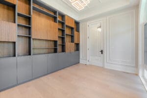 Empty modern room with built-in wooden shelves and light flooring.