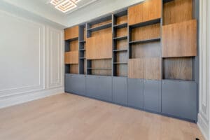 Modern empty wooden wall unit with black lower cabinets in a bright room.