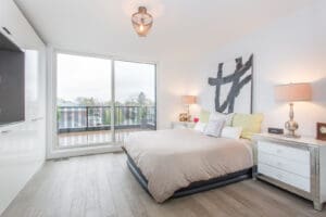 Bright modern bedroom with large windows and balcony.