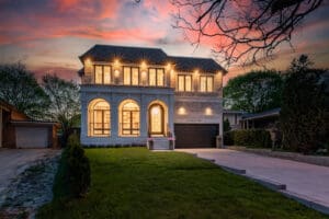 Elegant two-story home illuminated at sunset with a landscaped lawn.