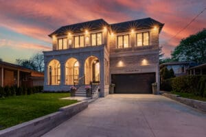 Elegant two-story house with warm lighting at sunset.