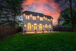 Elegant two-story house illuminated at sunset with vibrant sky.