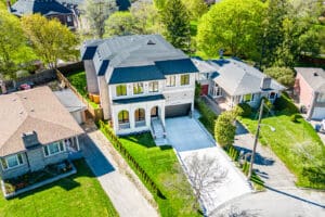 A beautiful two-story house with a spacious driveway and lush greenery.