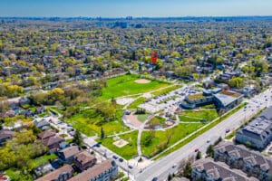 Aerial view of a park surrounded by urban housing with clear skies.