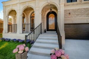 Elegant arched doorway with stairs and blooming hydrangeas.