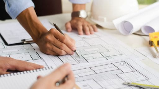 Two people reviewing architectural blueprints together.